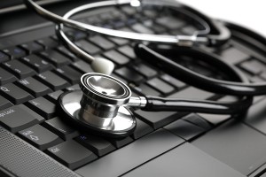 Stethoscope resting on a computer keyboard - concept for online