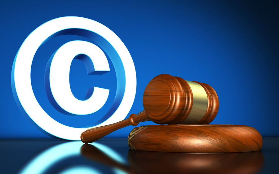 Intellectual property and digital copyright laws conceptual illustration with copyright symbol and icon and a gavel on blue background.
