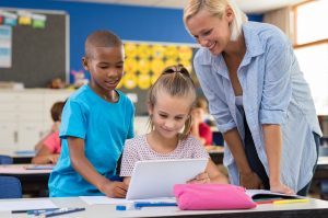 Die Lehrerin hilft ihren Schülern, digital zu lernen und den Papierverbrauch zu reduzieren